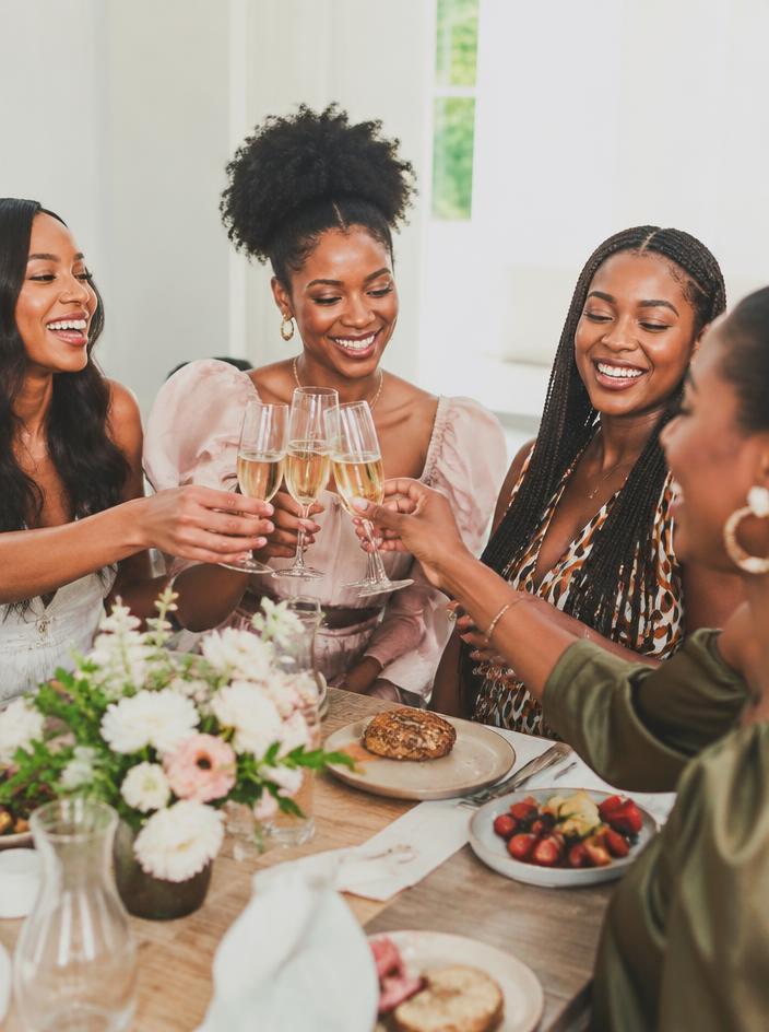 Friends toasting champagne at a bright brunch